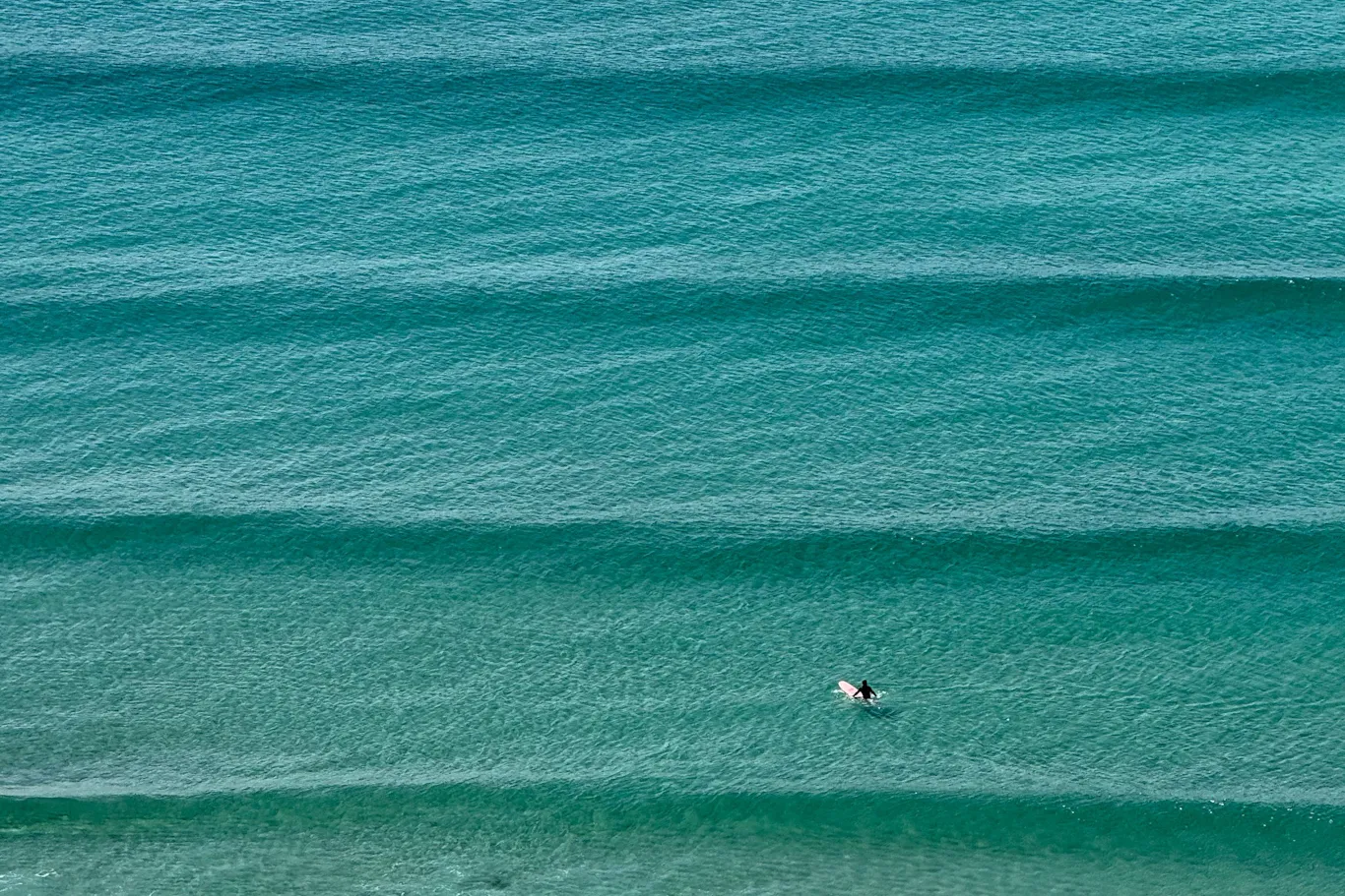 A set of waves rolling in with a surfer